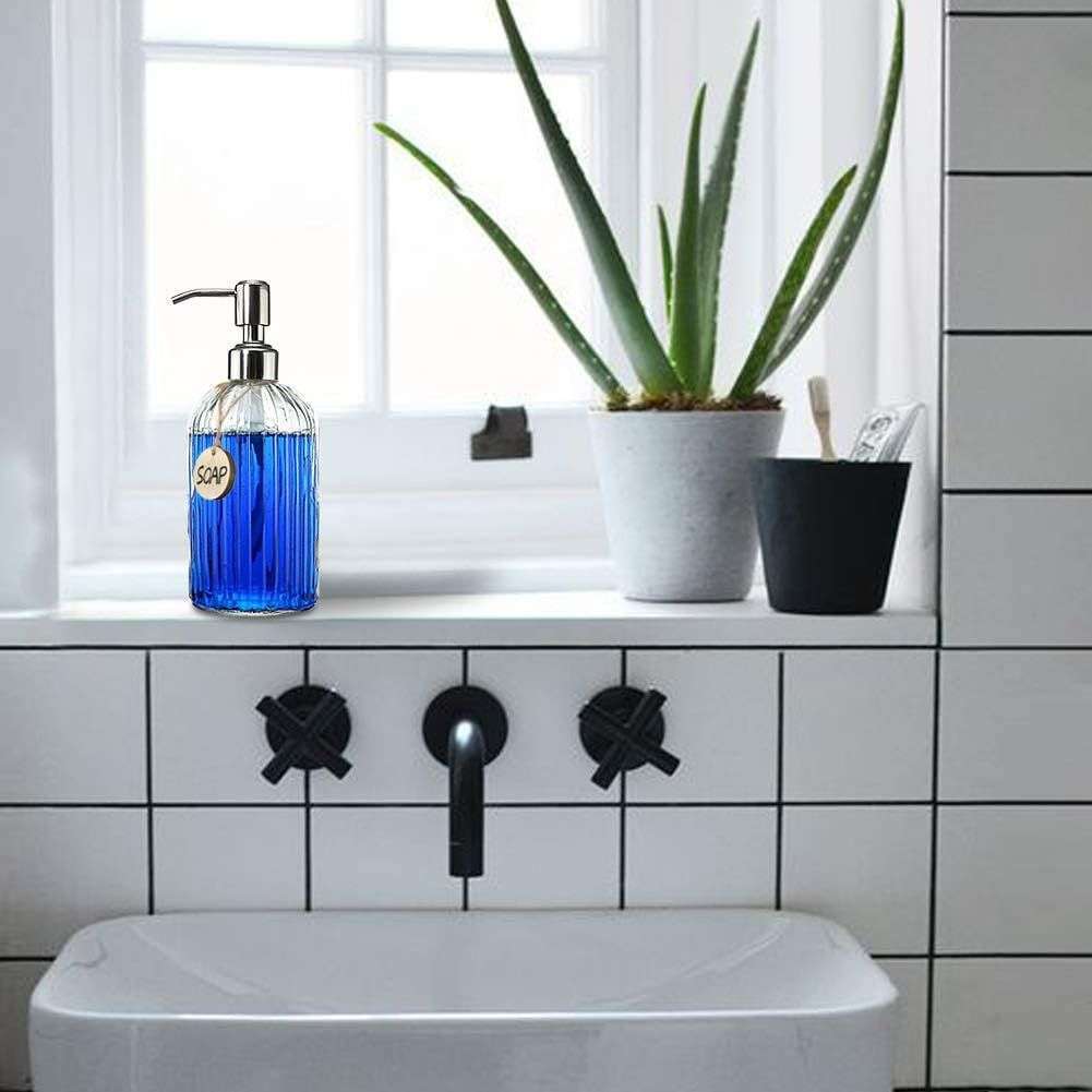 Aesthetic amber glass soap dispensers placed on a white sink in a neutral-toned bathroom, styled with minimal decor.